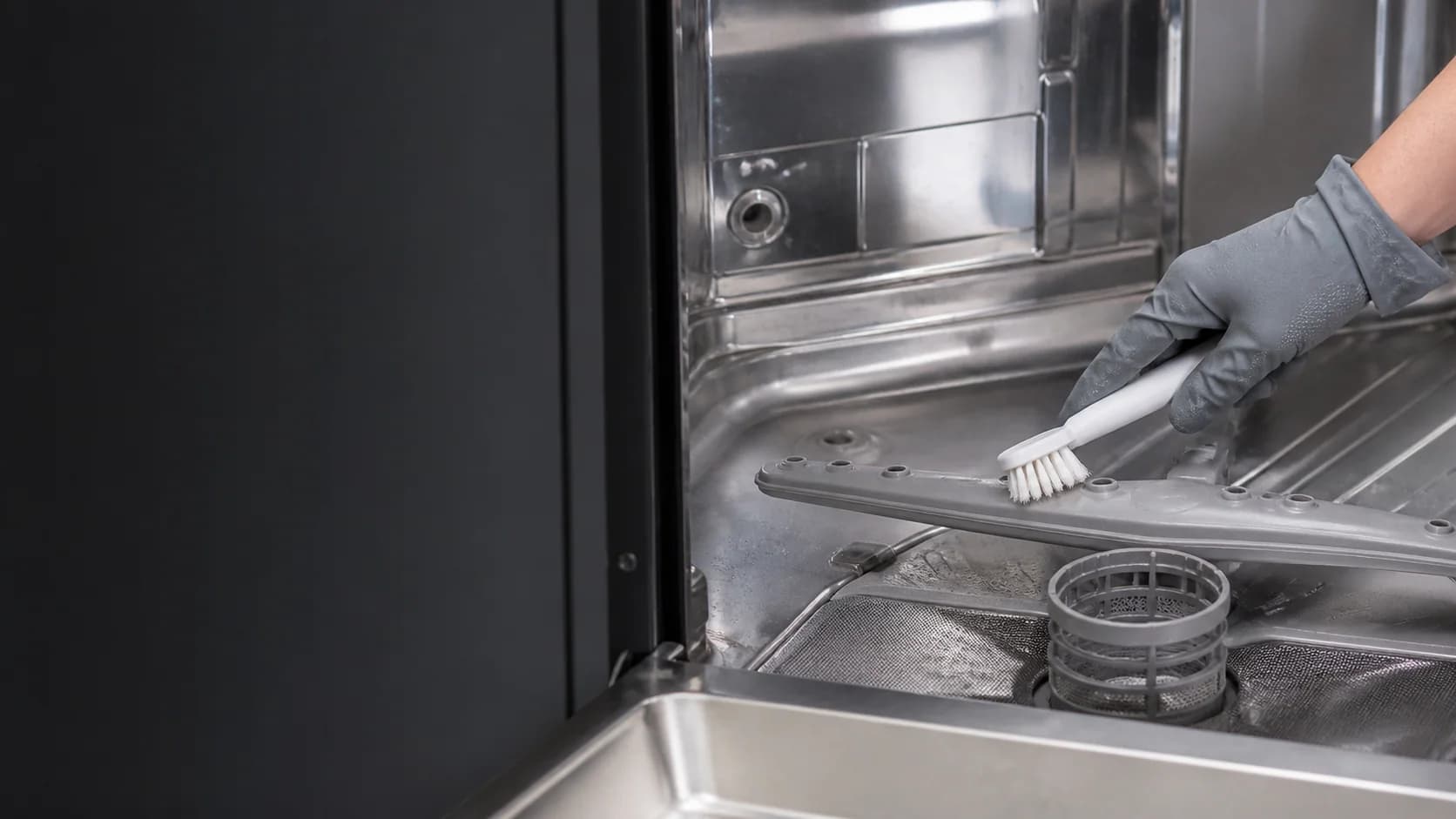 Dishwasher spray arm and filter being checked for blocked water flow
